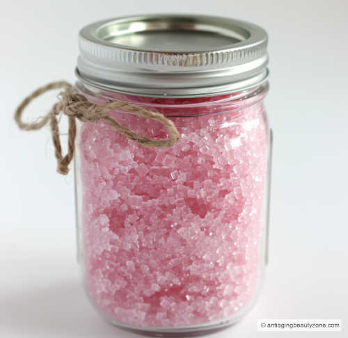 A mason jar filled with pink homemade sugar body and face scrub.